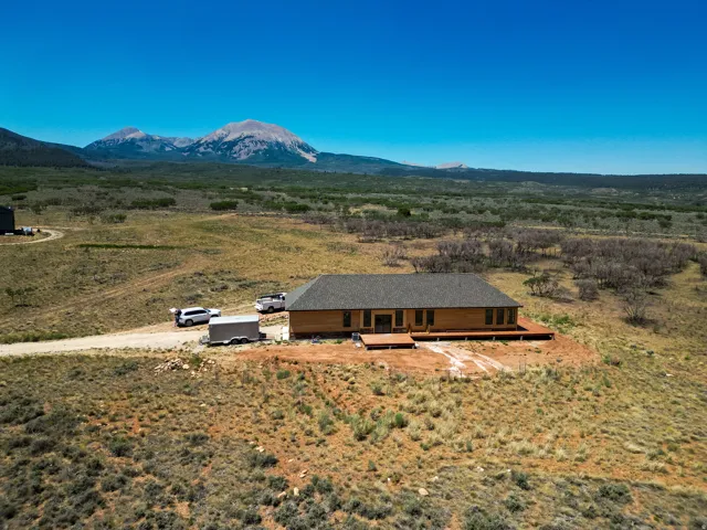 Ranch-style residence featuring wood siding and a dark shingle roof
