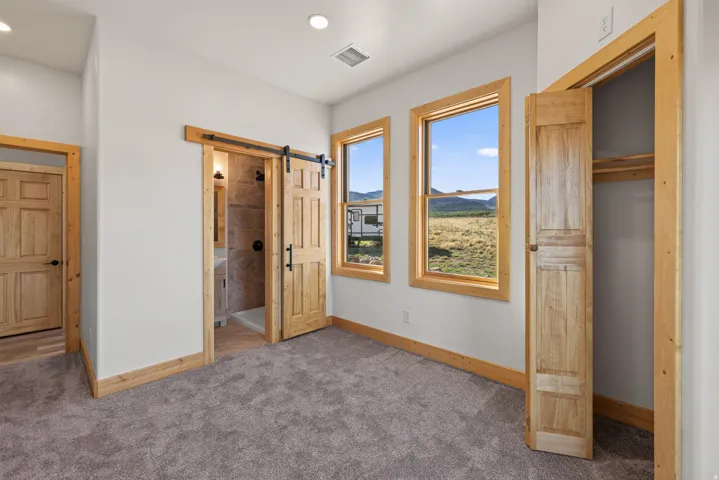 Wall-to-wall carpeting and natural wood trim accents