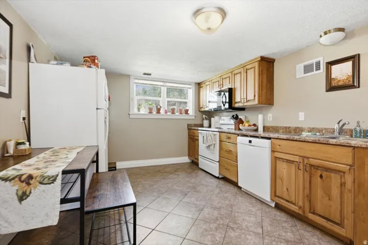 Kitchen featuring wood-finish cabinetry, tile flooring, and a double window