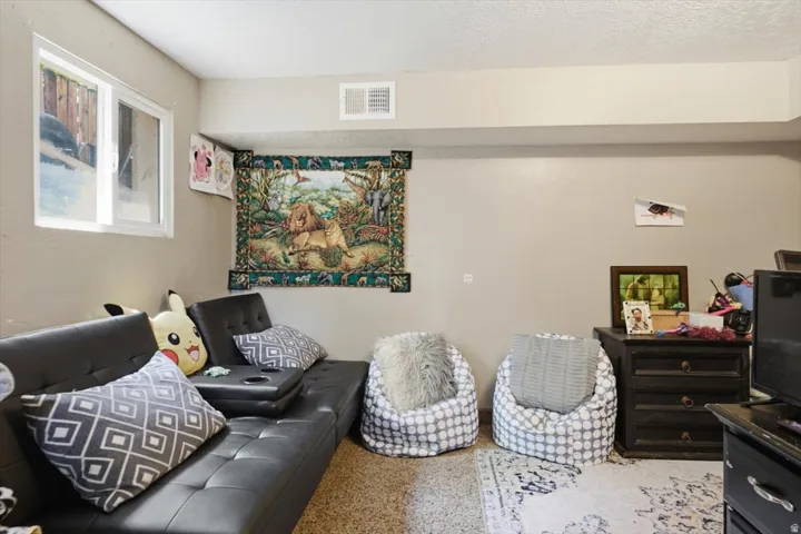 Finished room featuring a single-pane window, light beige wall paint, a white ceiling, overhead ductwork, and a light-colored carpeted floor