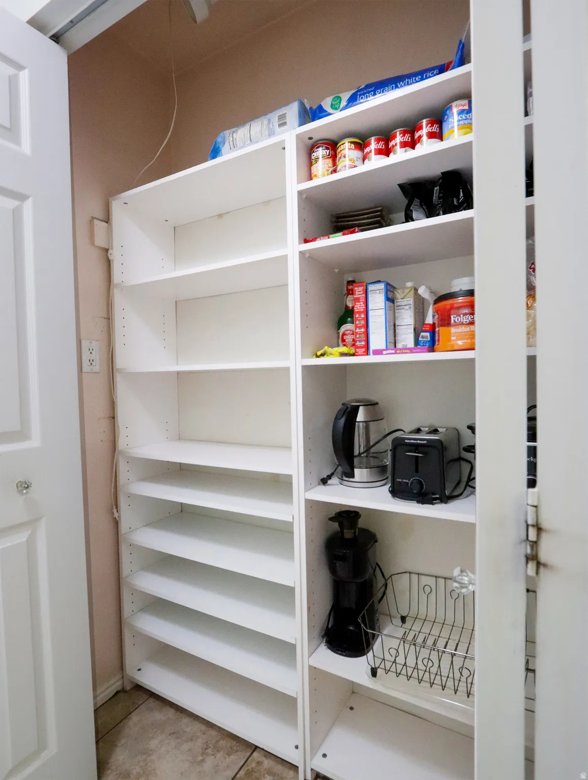Built-in shelving system with adjustable white shelves, providing ample vertical storage