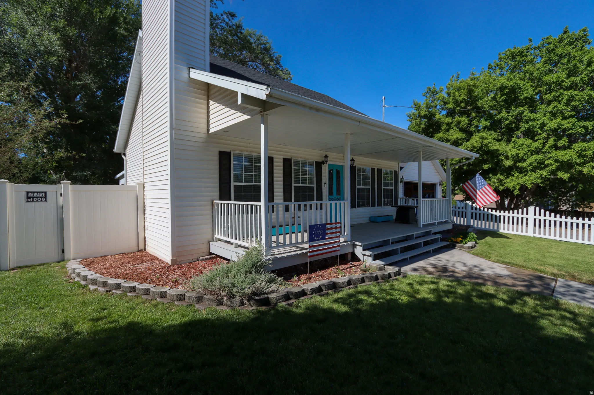 White siding exterior with a covered porch and white railings