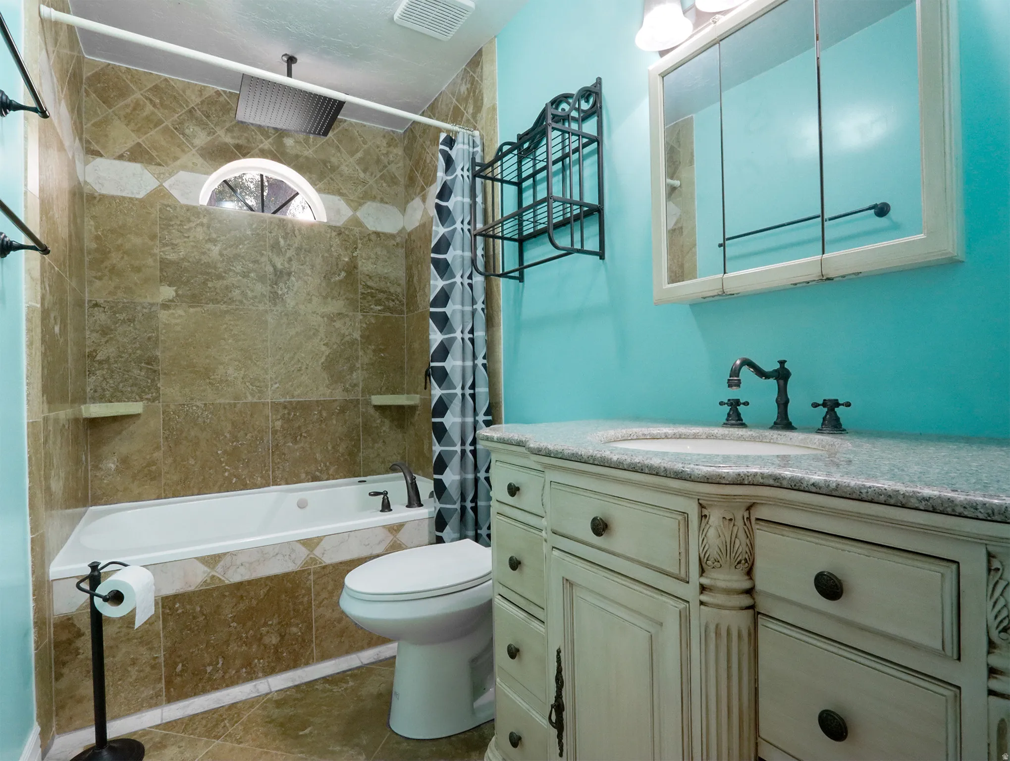 Bathroom featuring a corner soaking tub with tile surround, a built-in medicine cabinet, and a vanity with an integrated sink and stone countertop