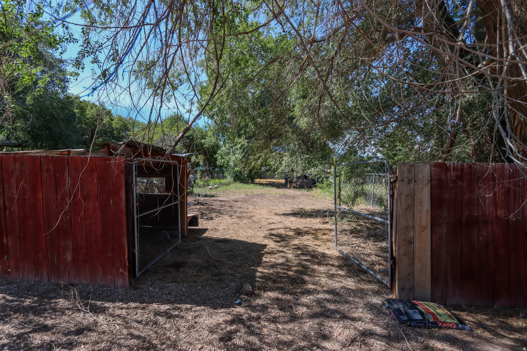 Red wood-paneled structure with a chain-link door
