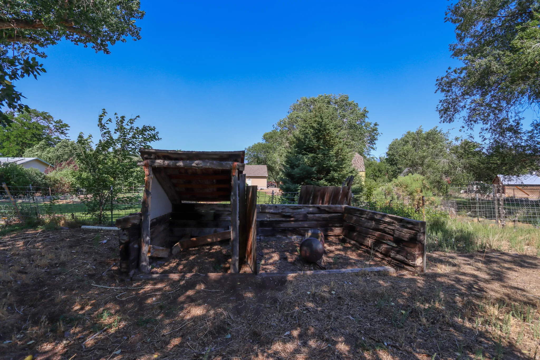 Rustic outdoor structure with a sloped roof and log-style sides