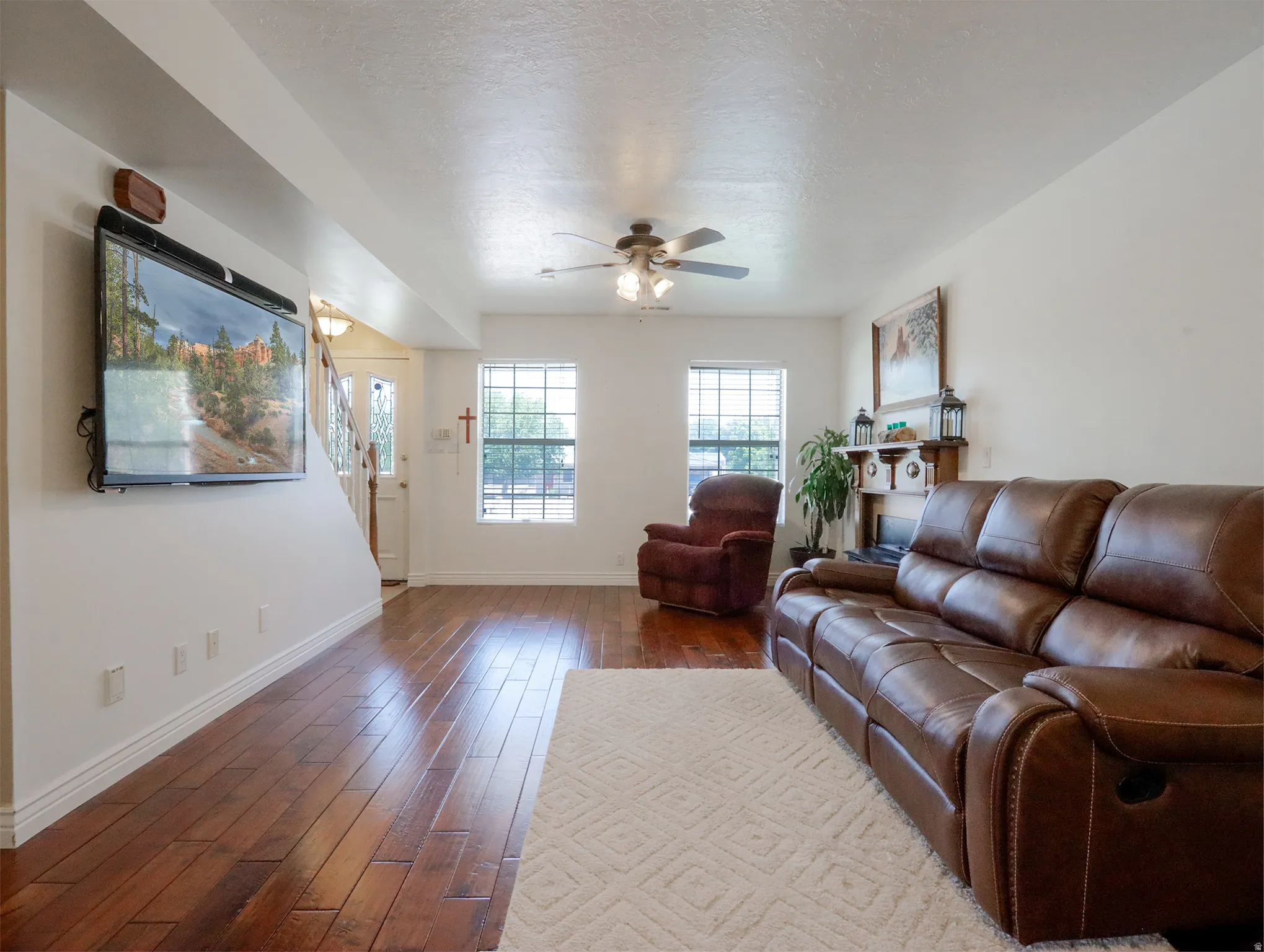 Open concept living area featuring wood-finish flooring, white baseboards, and a neutral wall palette