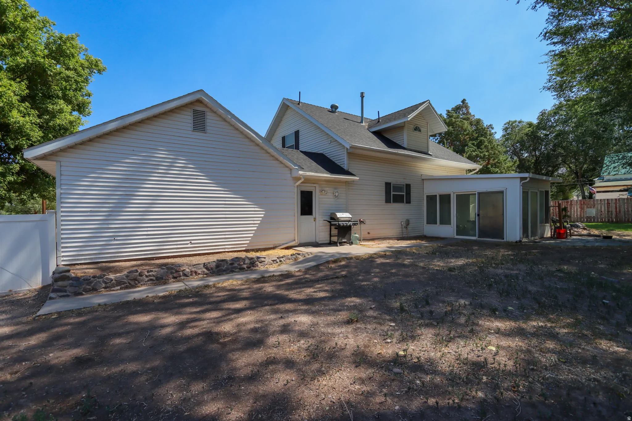 Rear exterior featuring a detached garage with vinyl siding and a gable roof