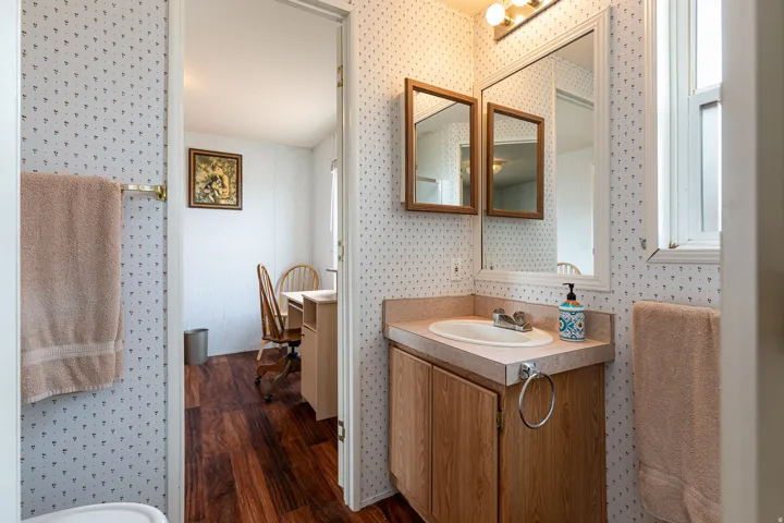 Bathroom vanity featuring a light wood-finish cabinet, integrated sink, and laminate countertop