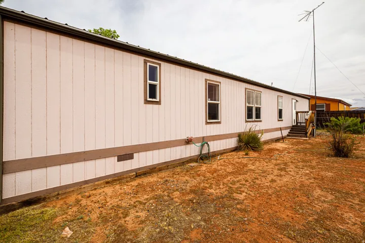 White vertical panel siding with brown trim and multiple windows