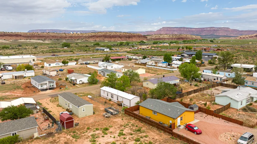 Residential properties situated in a desert landscape, featuring a prominent mesa in the background