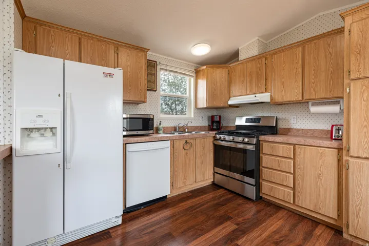 Kitchen featuring wood-finish flooring, wood cabinetry, and a stainless steel oven/range