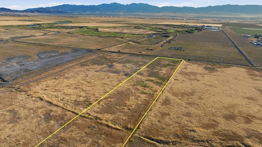 Expansive land parcel featuring natural topography and distant mountain ranges