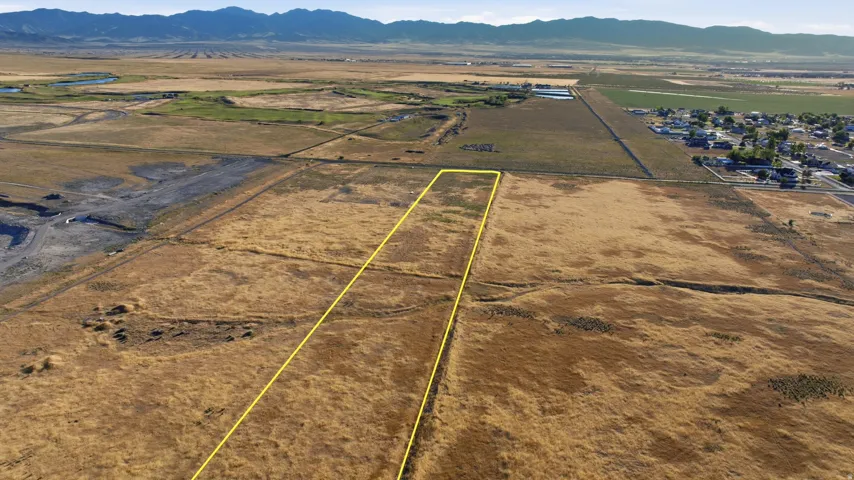 Expansive land parcel outlined in yellow with a backdrop of distant mountains