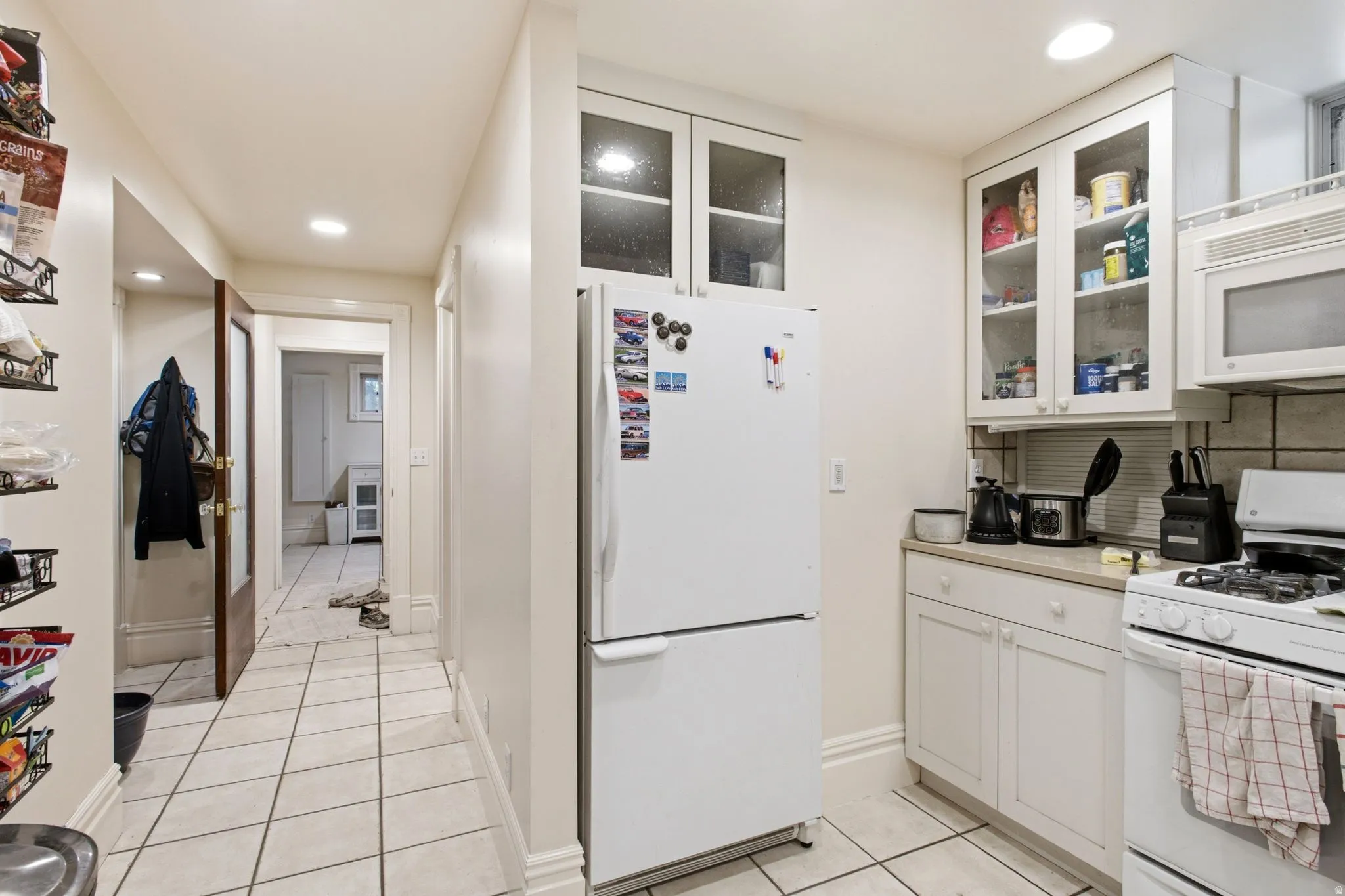 Kitchen featuring white cabinetry, white appliances, and tiled flooring