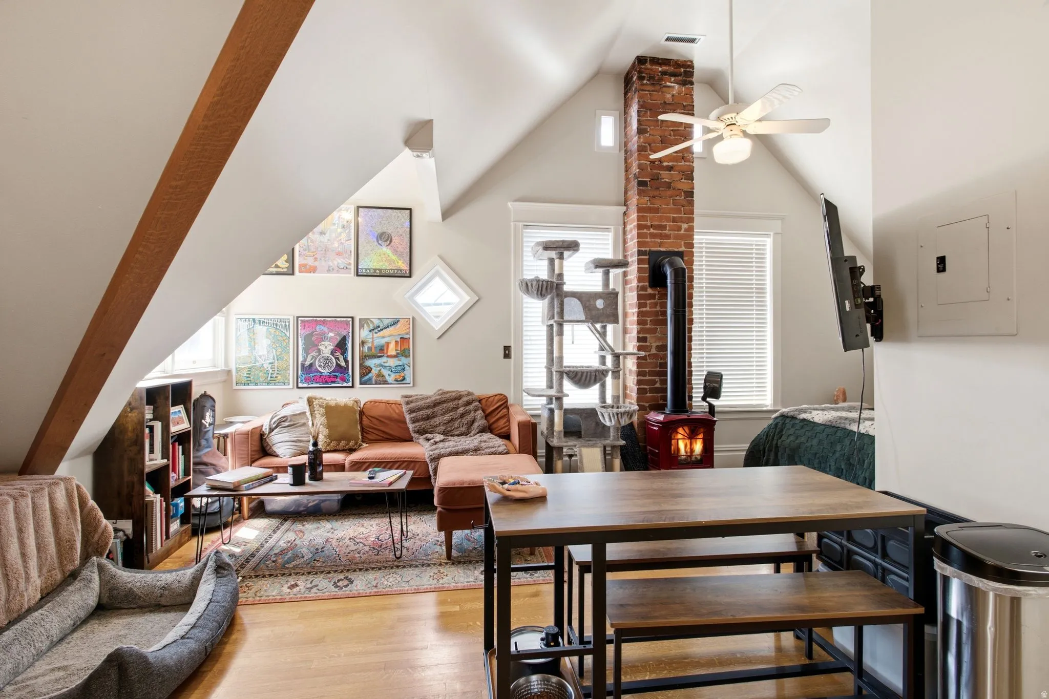 Open-concept living area with sloped ceilings and exposed wood beam