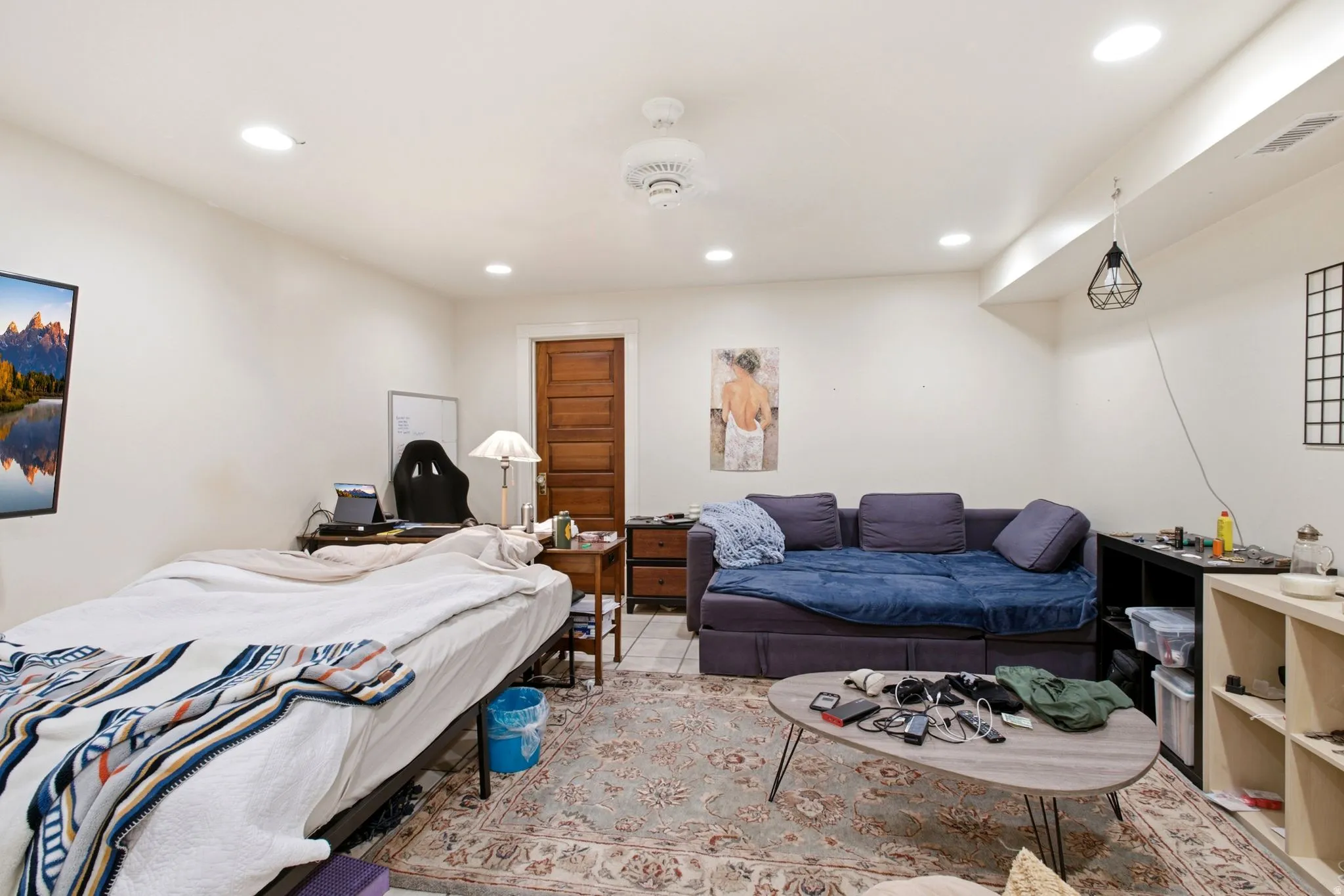 Spacious room featuring neutral wall tones, recessed lighting, a ceiling fan, a paneled wood door, and light-toned flooring