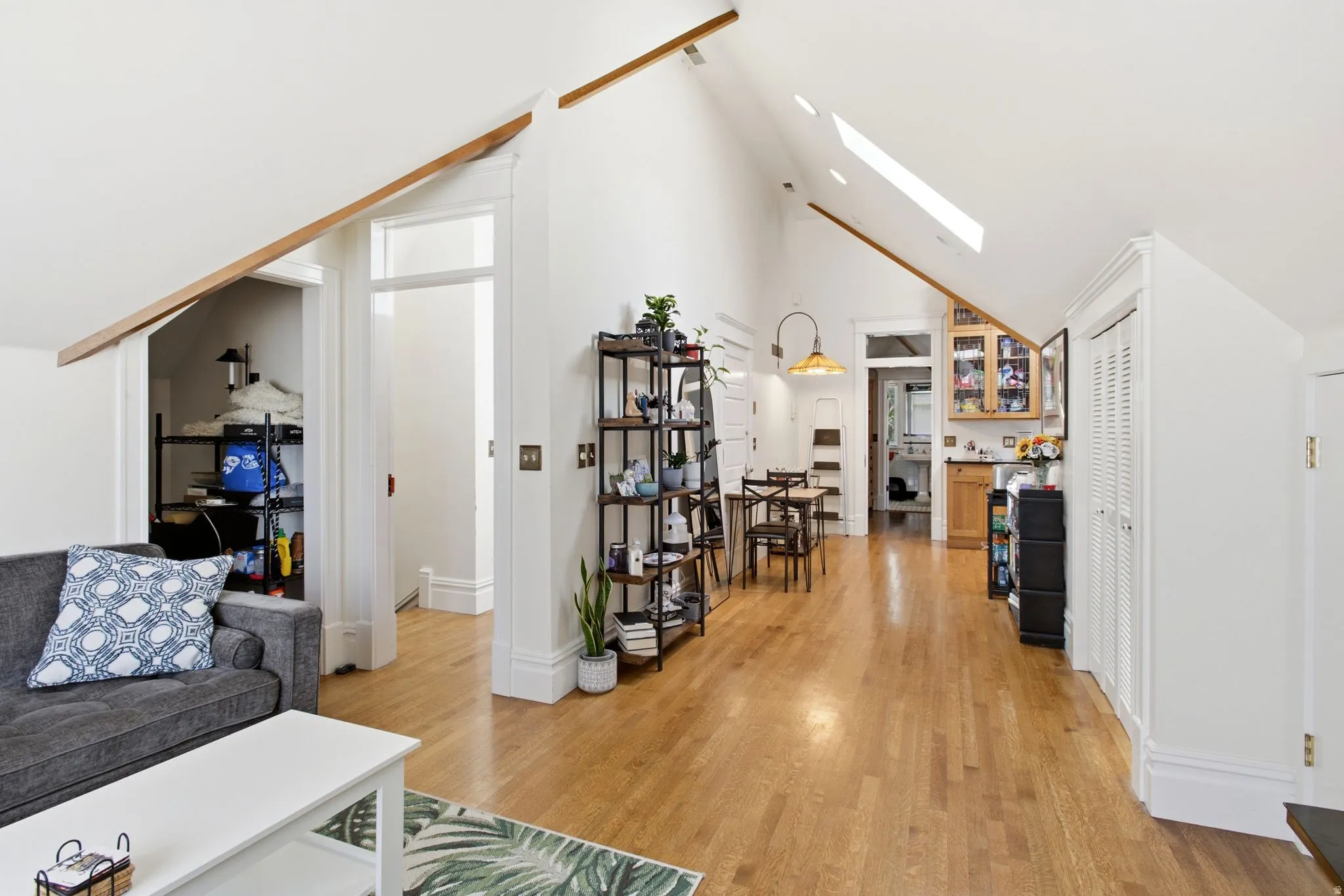 Vaulted ceilings with exposed beams and skylights complement the wood-finish flooring