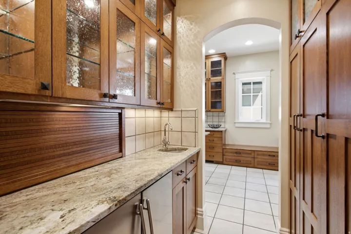 Built-in cabinetry featuring glass-front uppers and a roll-top appliance garage