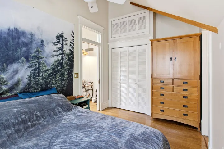 Hardwood flooring throughout, white bi-fold closet doors, and recessed storage cabinet