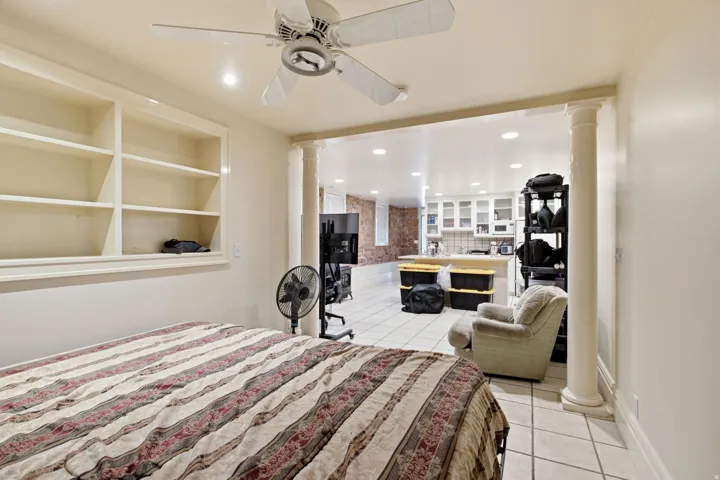 Open concept living space featuring a built-in shelving unit, overhead ceiling fan, recessed lighting, and tile flooring
