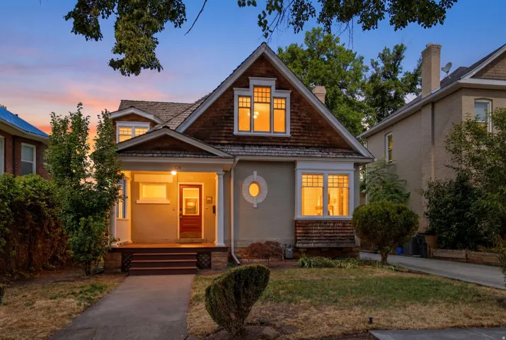 Craftsman-style exterior featuring a covered front porch, a prominent red entry door, and a multi-pane bay window