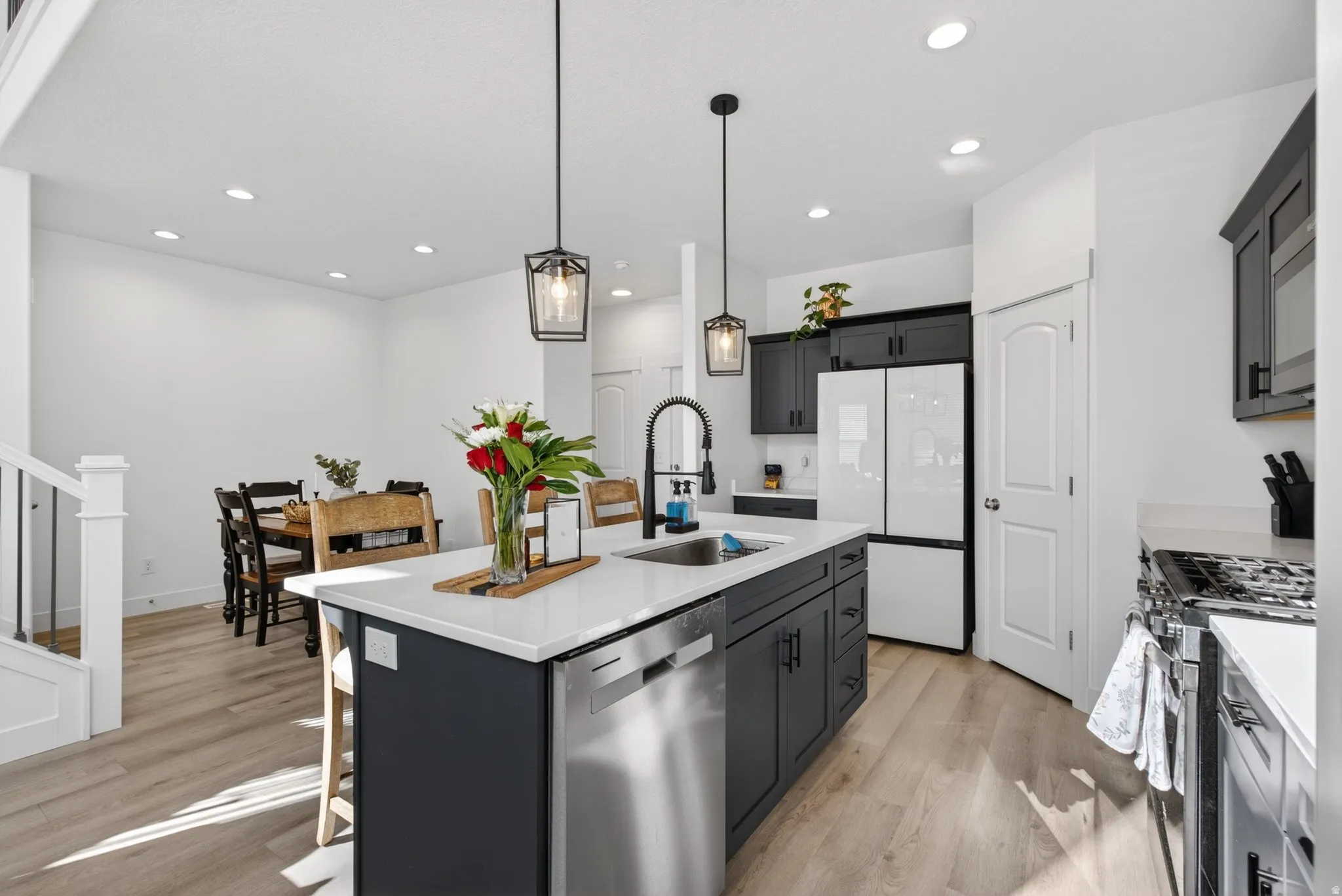 Kitchen island featuring a white countertop, undermount sink, and stainless steel dishwasher