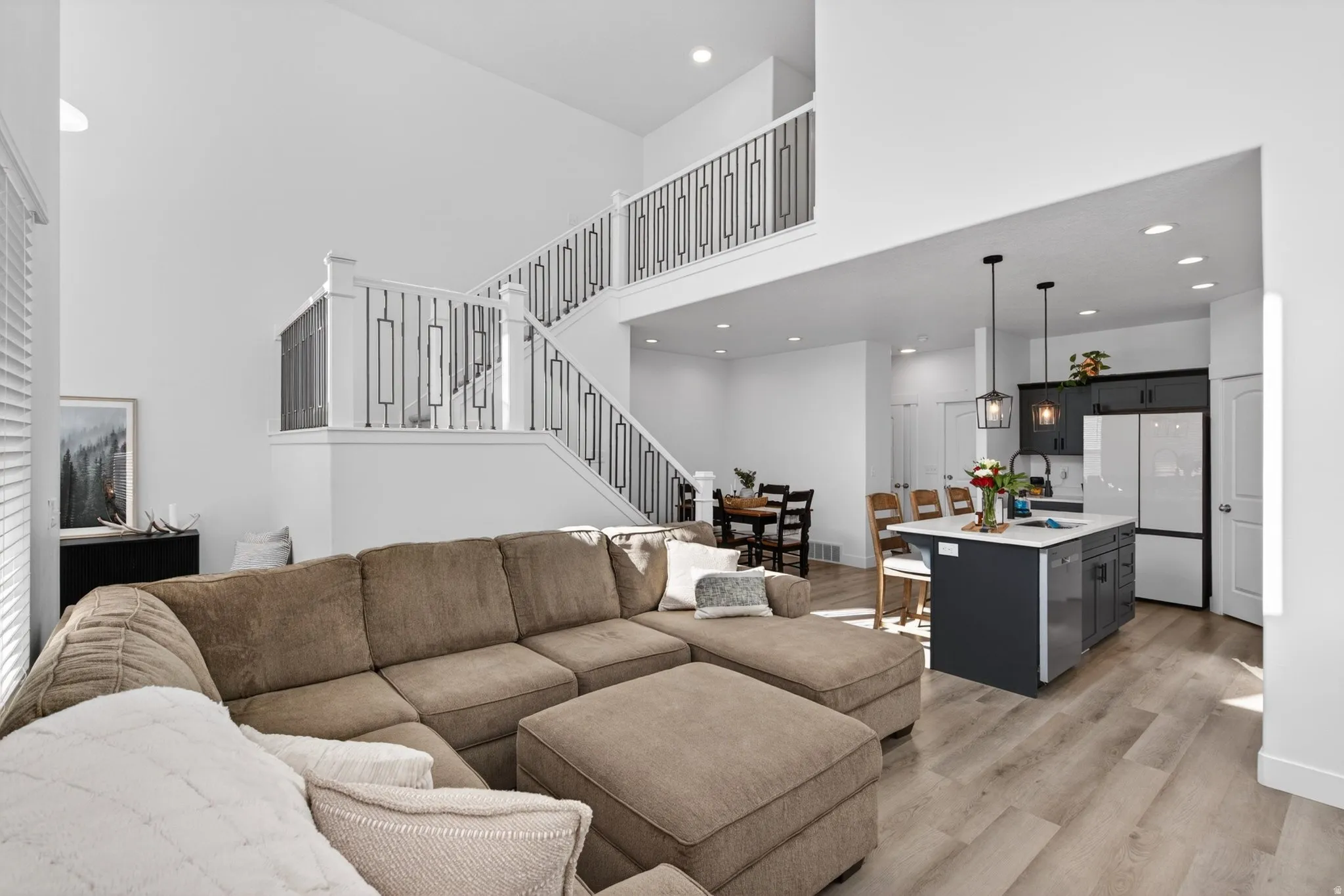 High ceilings and wood-finish flooring characterize this open concept living area