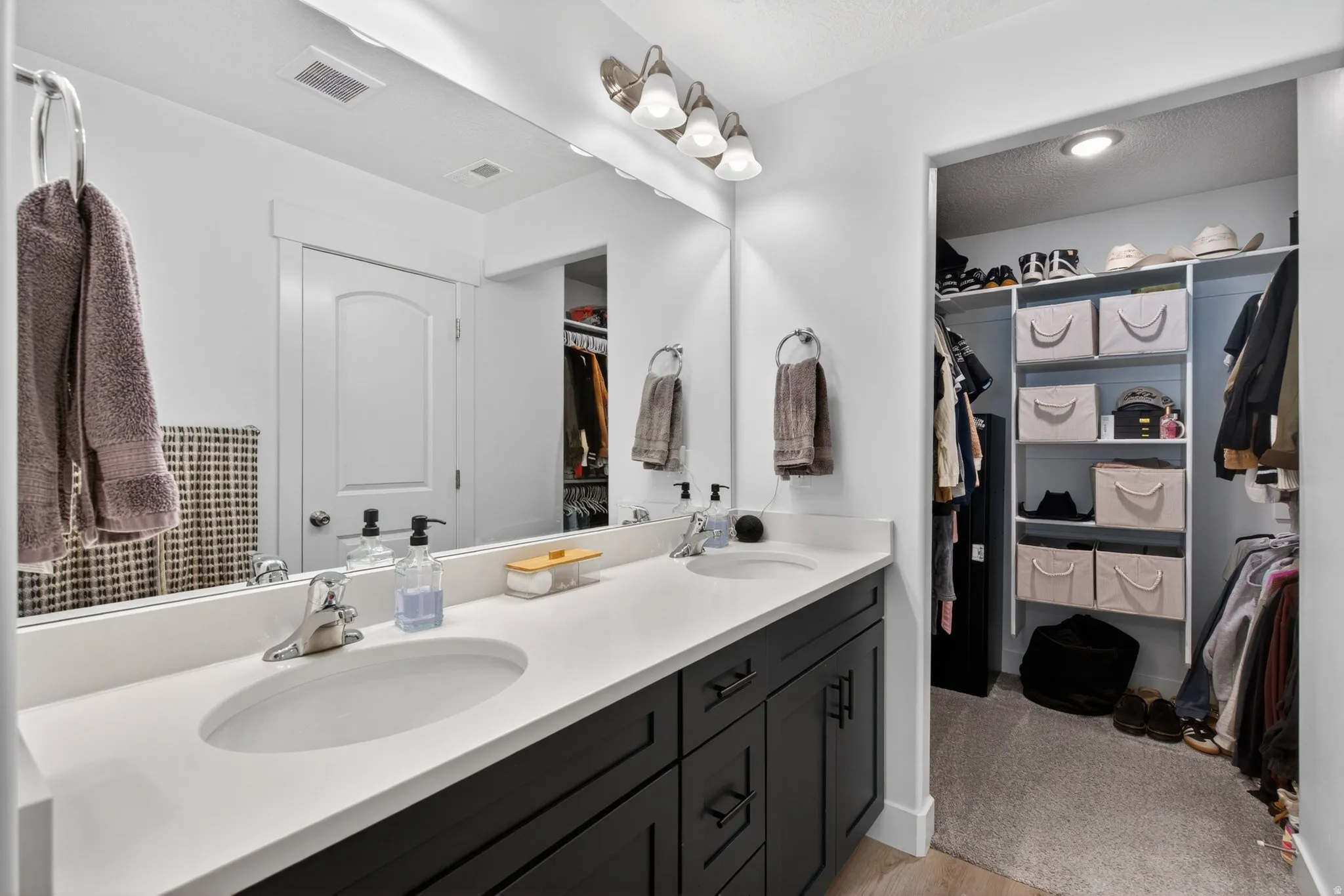 Dual sink vanity with white countertop and dark cabinetry