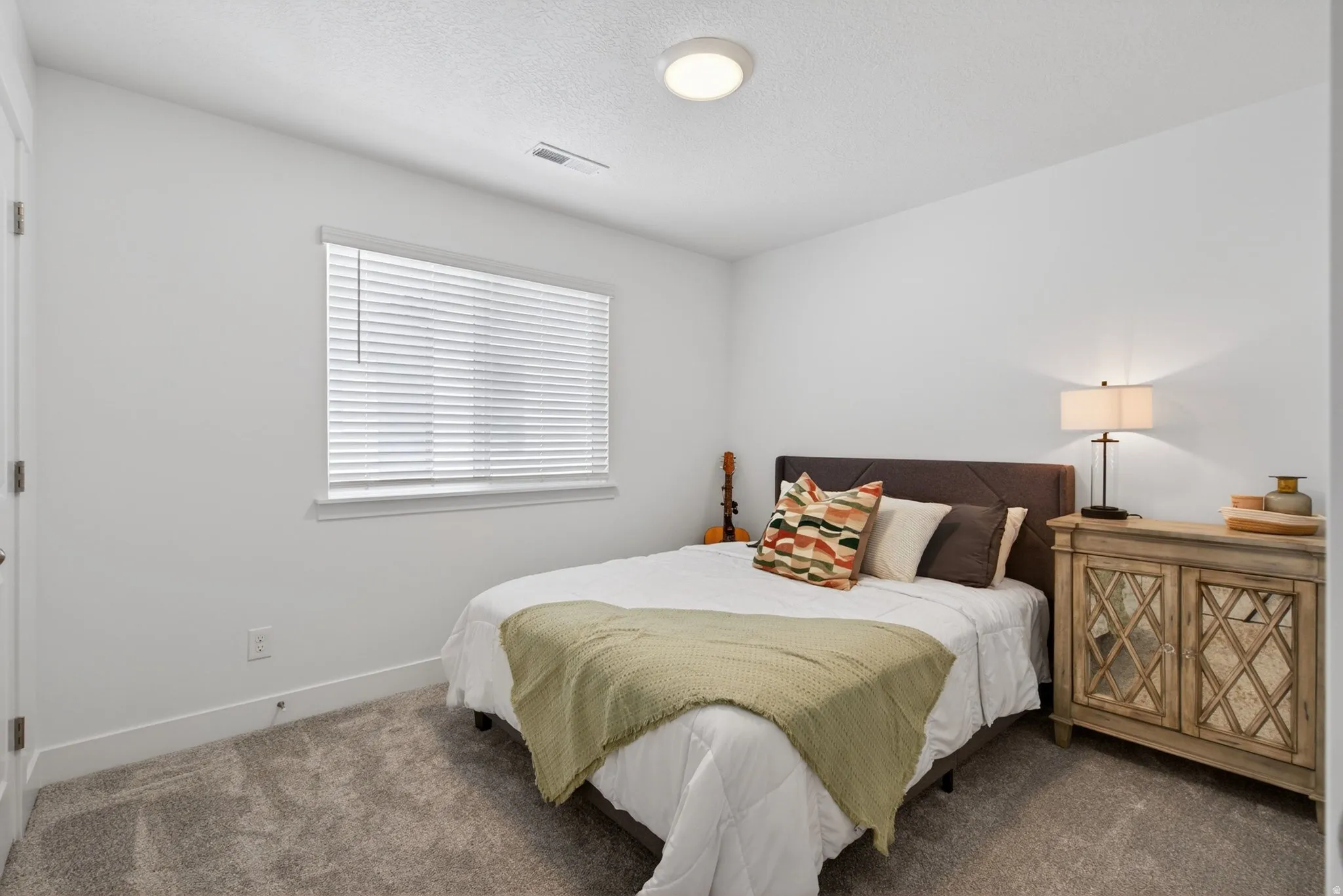 Neutral tone walls, recessed ceiling light, and window with blinds