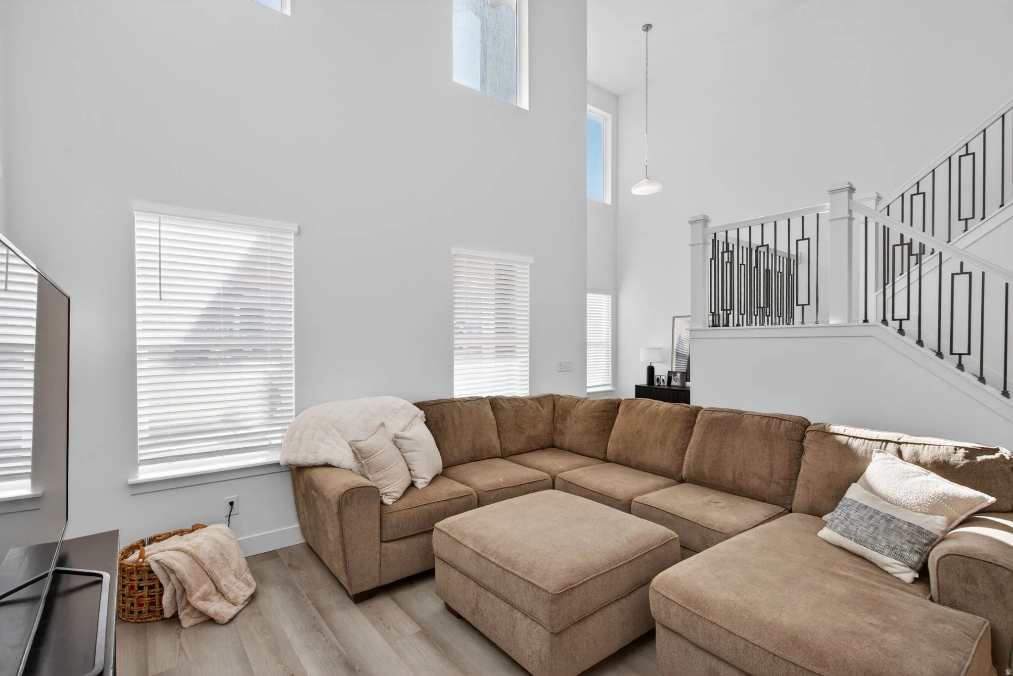 Living area with soaring ceilings and abundant natural light from multiple windows