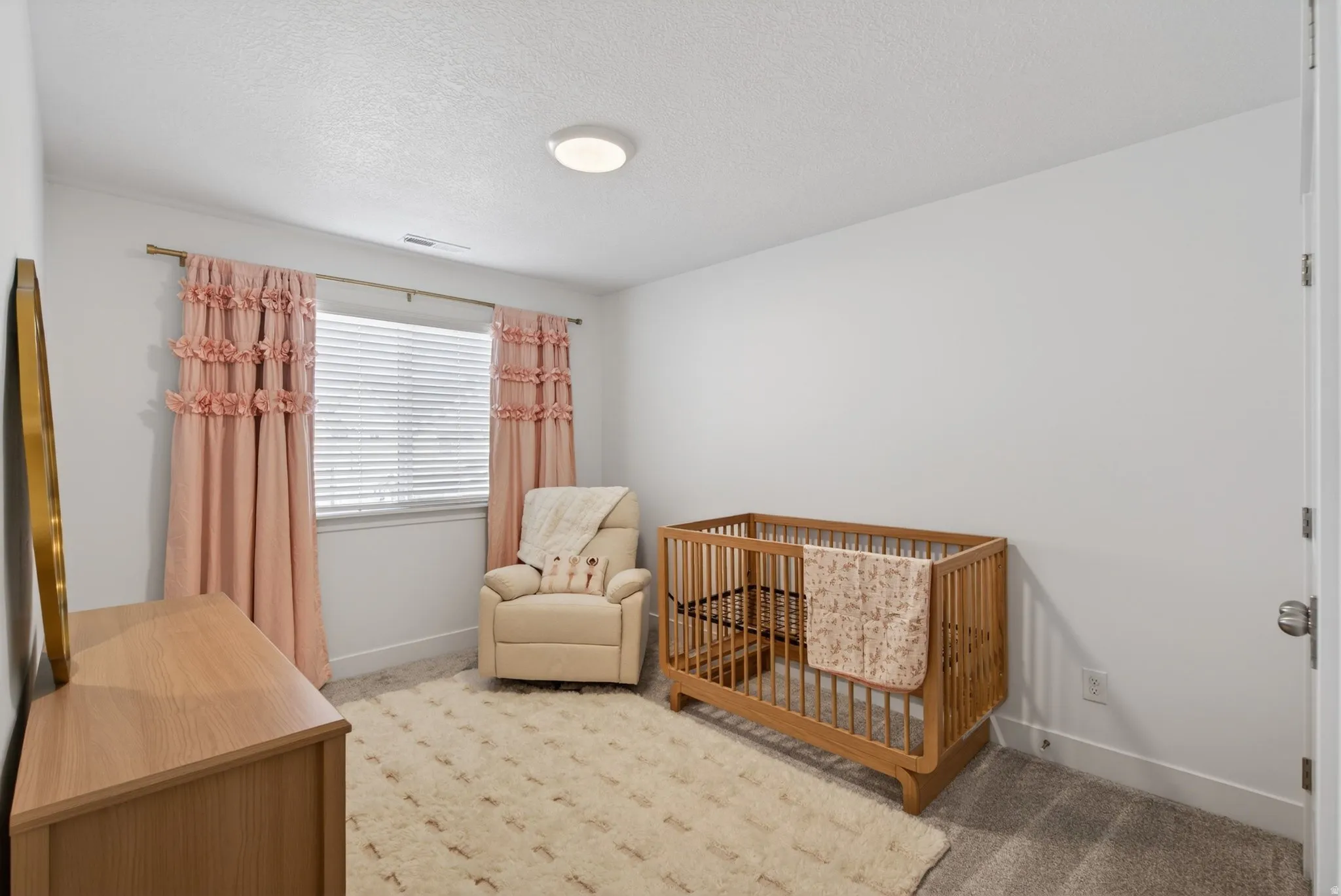 Carpeted room with a single window featuring horizontal blinds