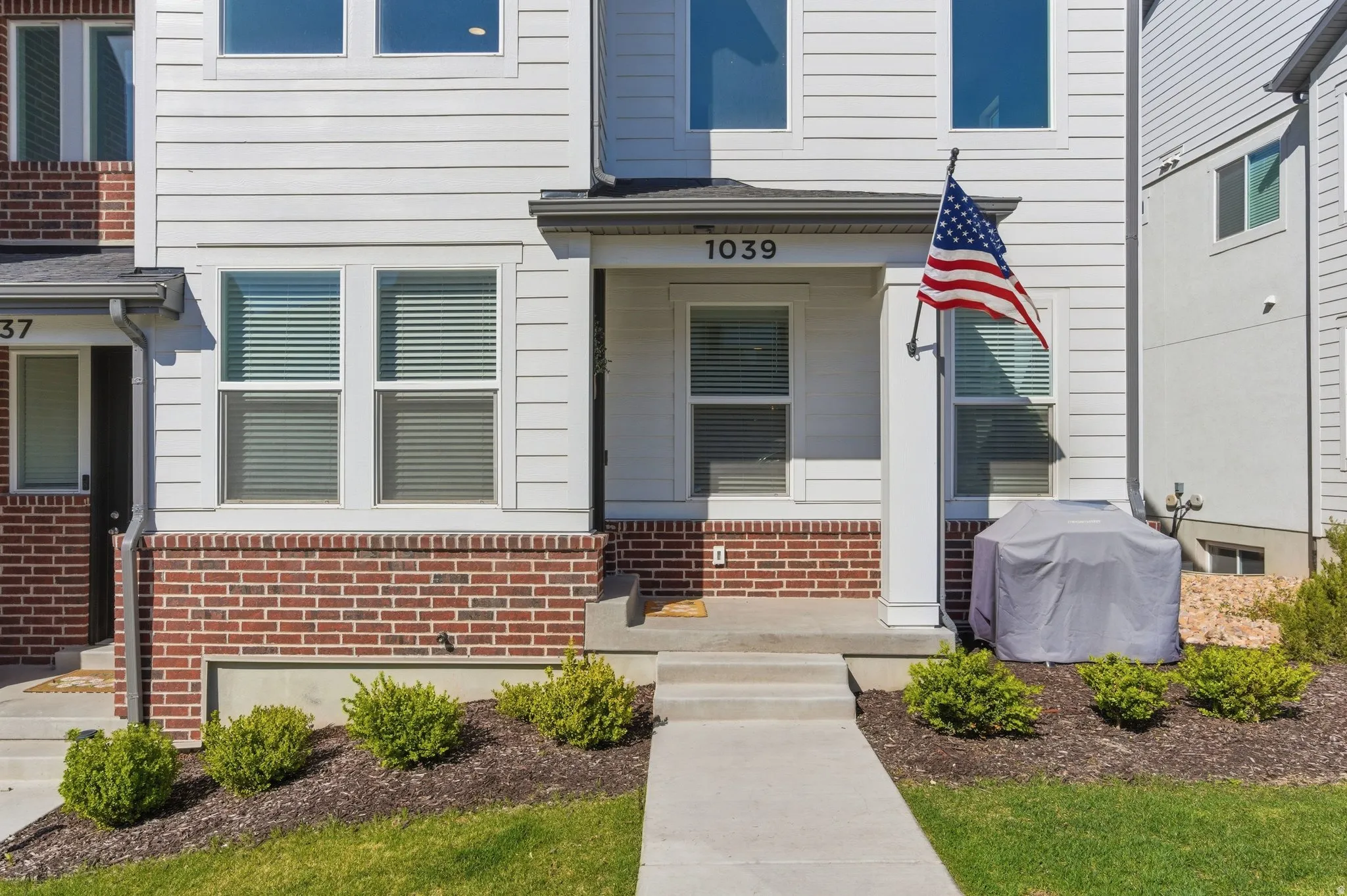 White siding exterior with a red brick facade