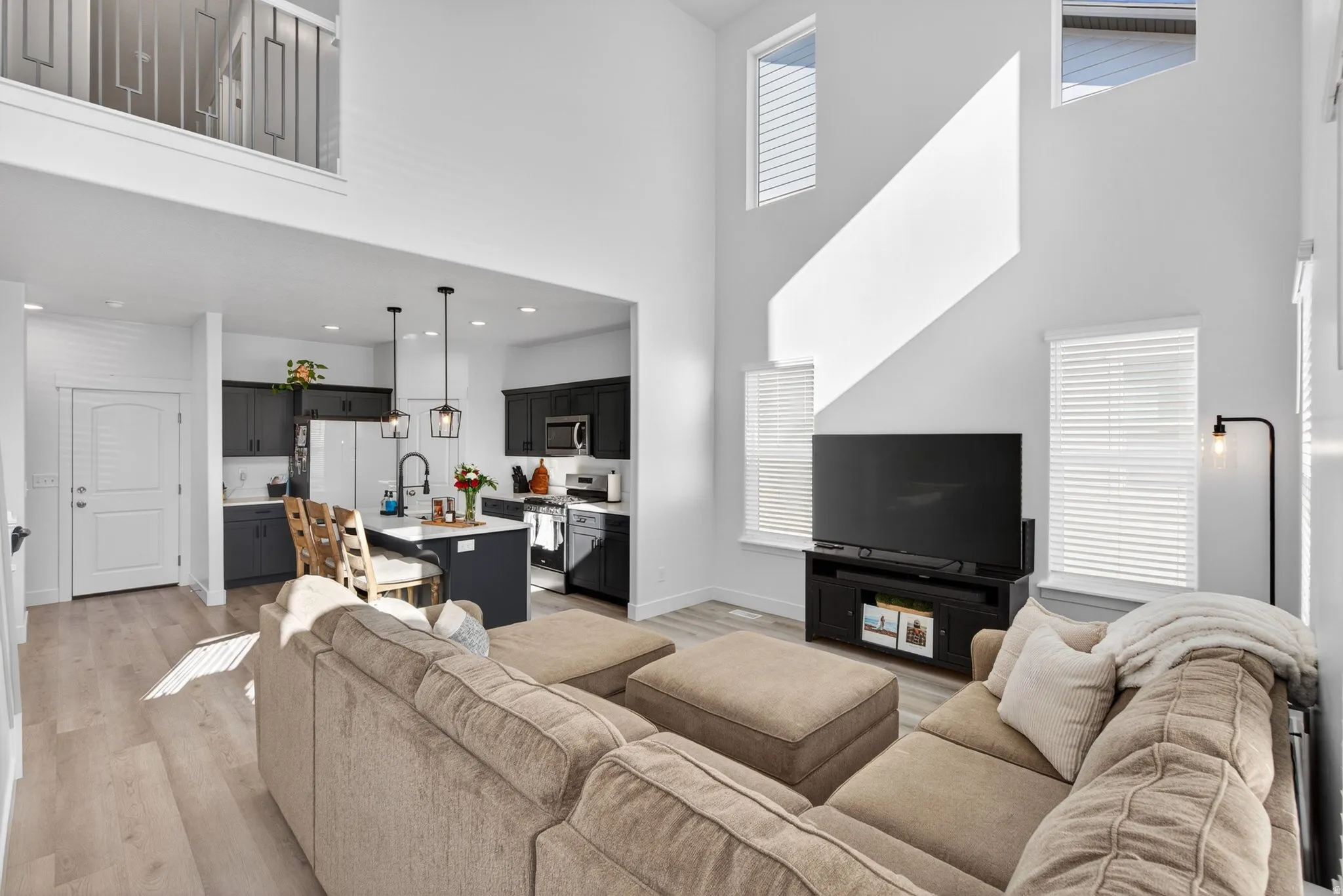Open-concept living space featuring high ceilings and light wood-finish flooring