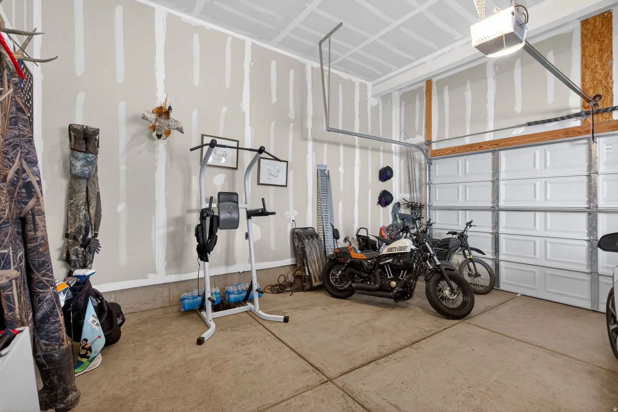 Spacious garage featuring a concrete floor, high ceilings, and a panel-style overhead door