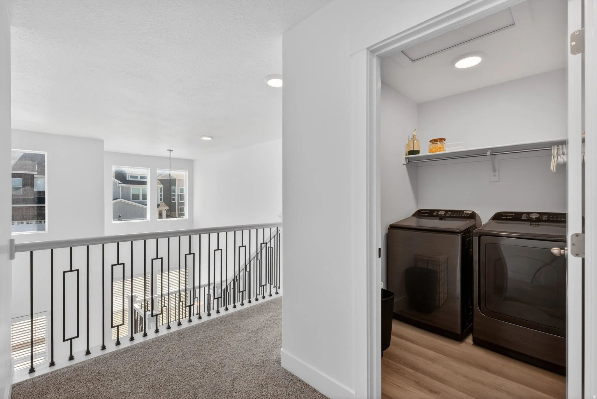 Dedicated laundry closet with wood-finish flooring and integrated shelving