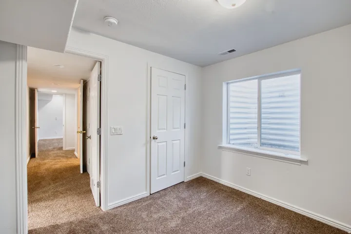 Carpeted room featuring white walls and a white trim package