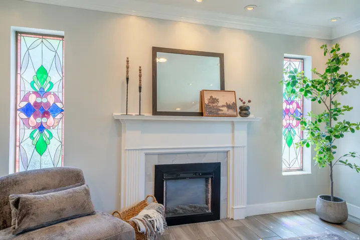 Fireplace featuring a white mantel, tile surround, and an electric insert