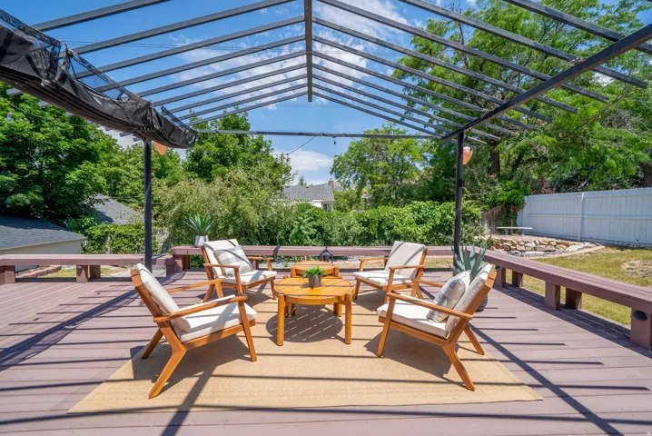 Expansive outdoor deck featuring a contemporary pergola with a retractable shade