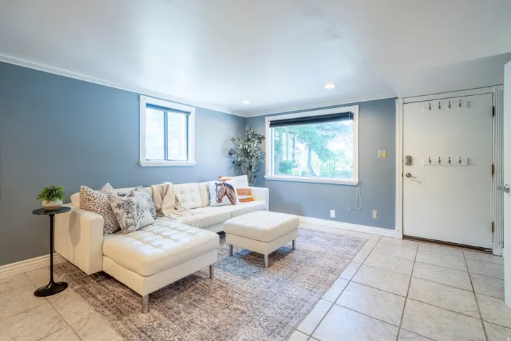 Recessed lighting illuminates the tiled flooring and light blue walls