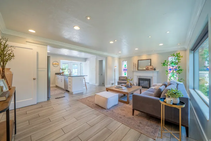 Spacious living area featuring wood-finish flooring, recessed lighting, and a fireplace with a mantel