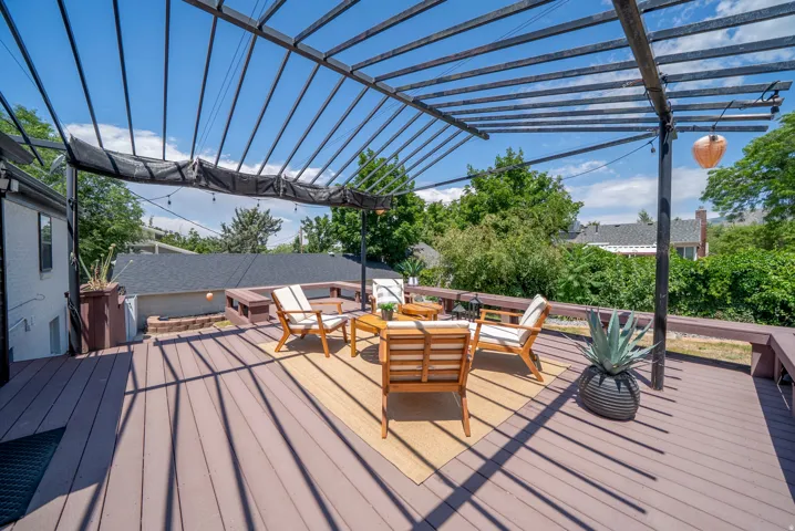Expansive outdoor deck featuring composite decking and a black metal pergola