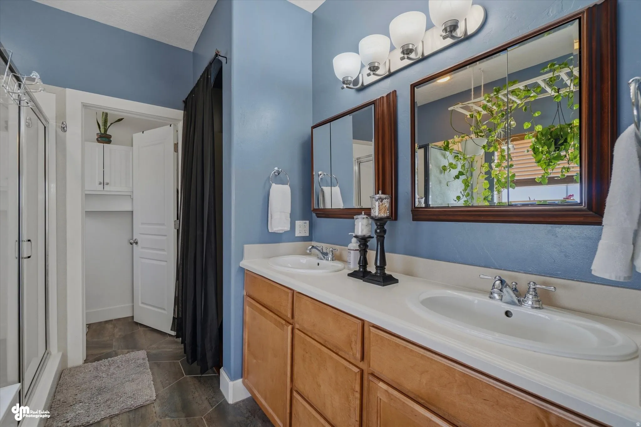 Bathroom featuring a double vanity with light wood-finish cabinetry and white countertops
