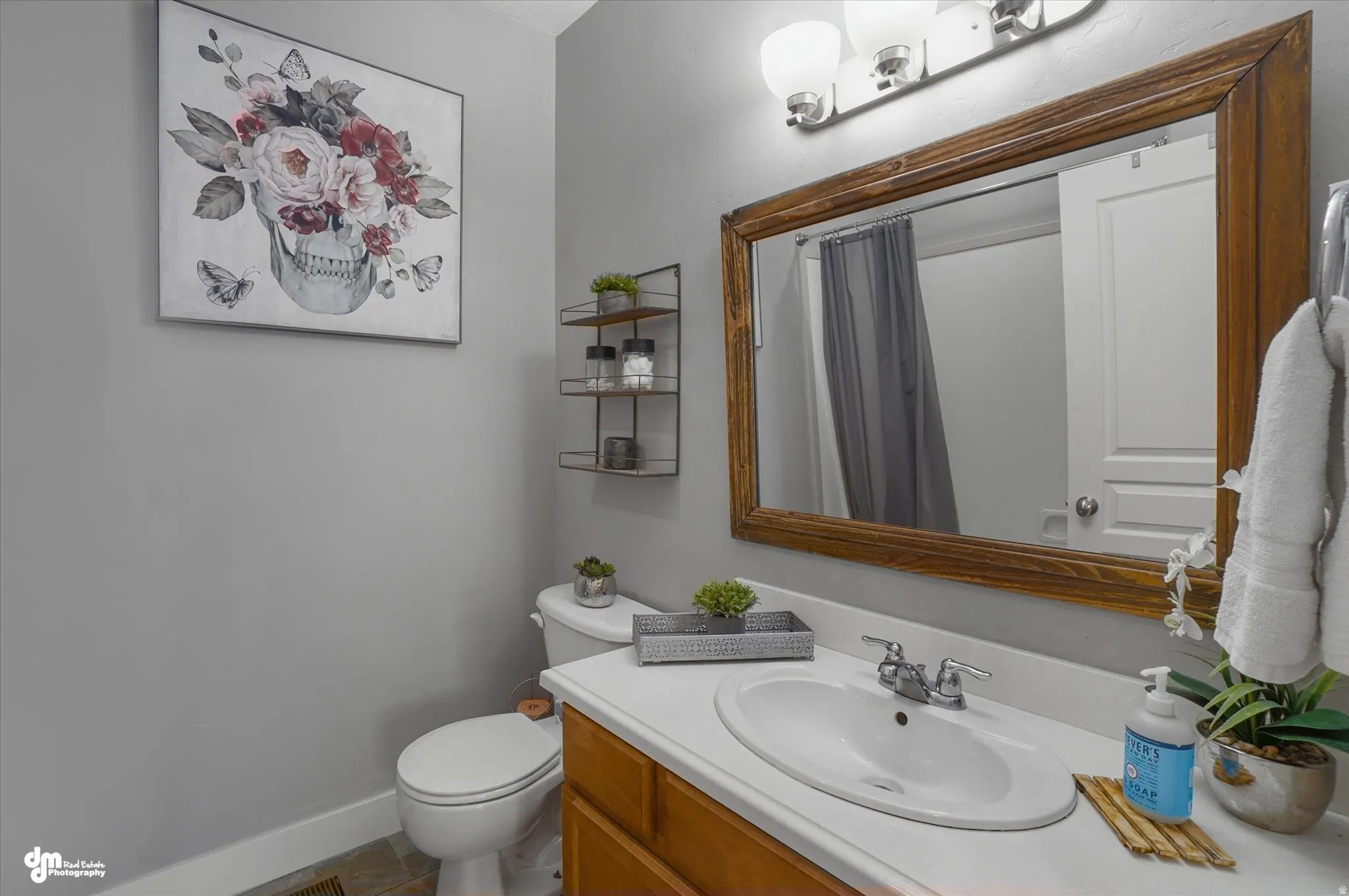 Bathroom vanity featuring a white countertop with an integrated sink, a two-handle chrome faucet, and a wood-frame mirror