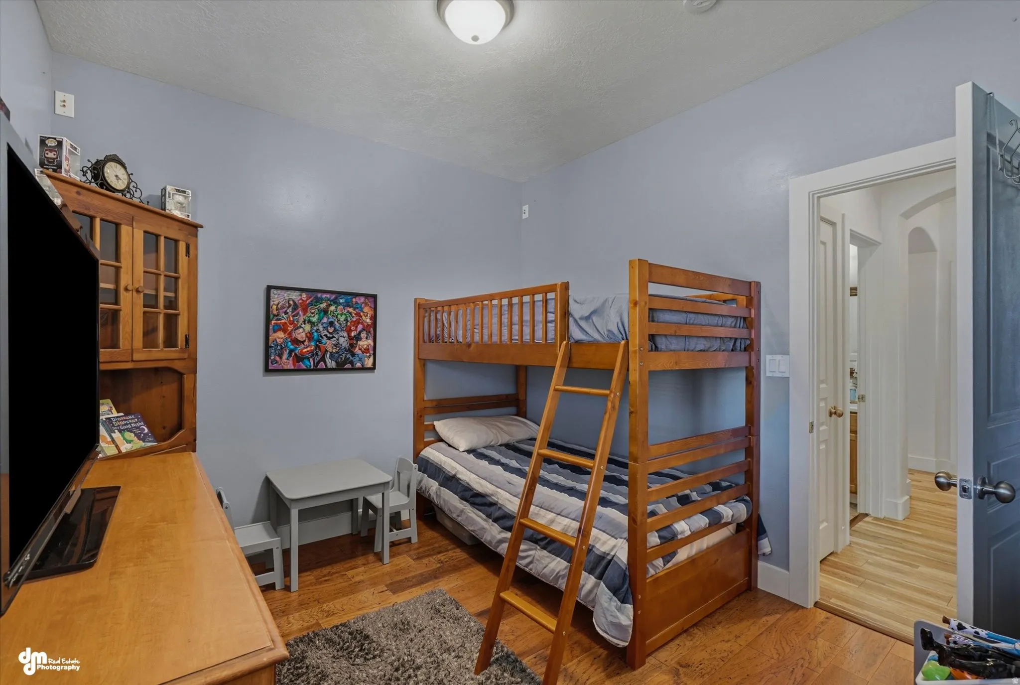 Hardwood-style flooring throughout this room, featuring light blue walls
