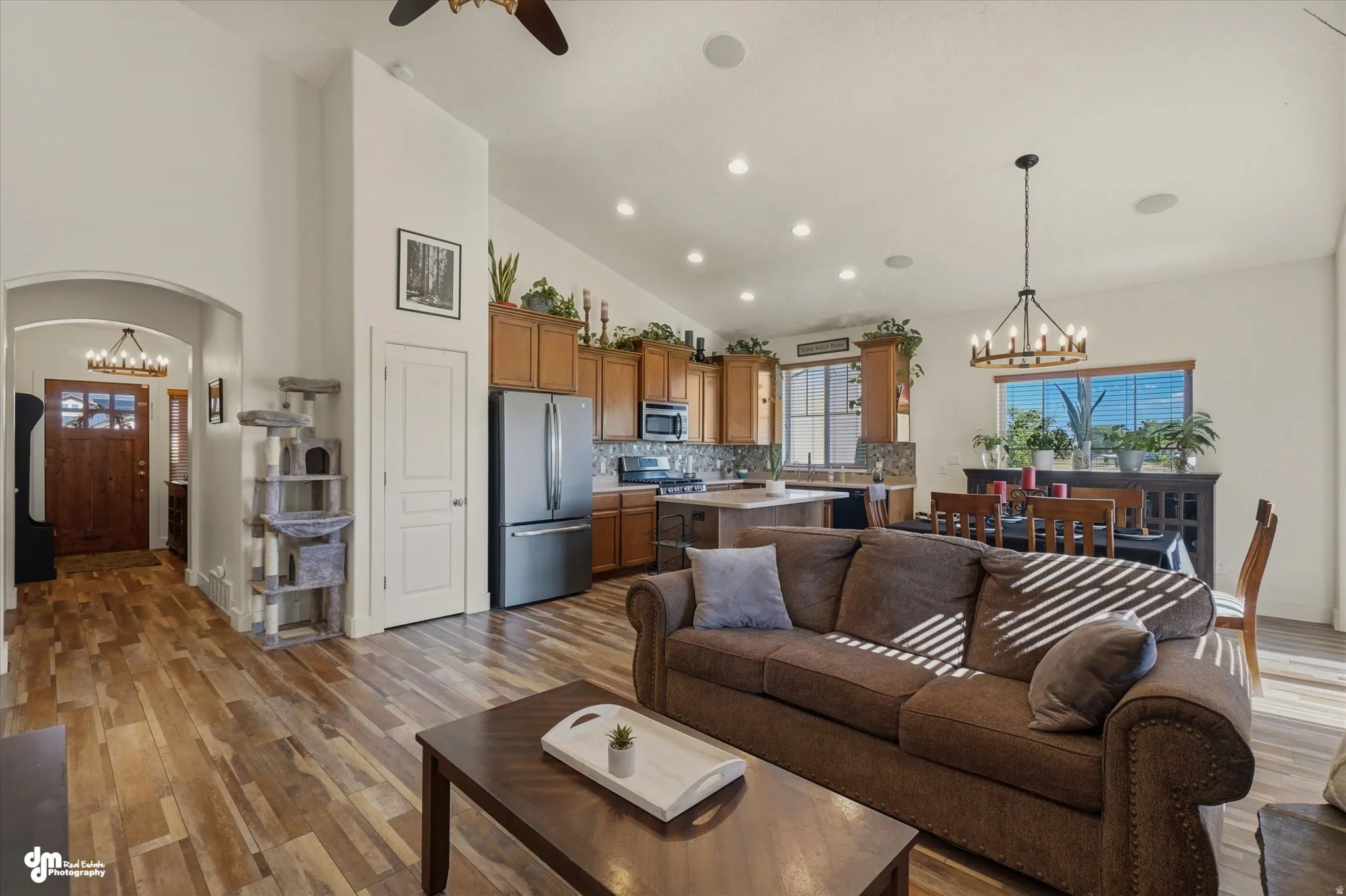 Open-concept living space featuring wood-finish flooring, recessed lighting, and vaulted ceilings