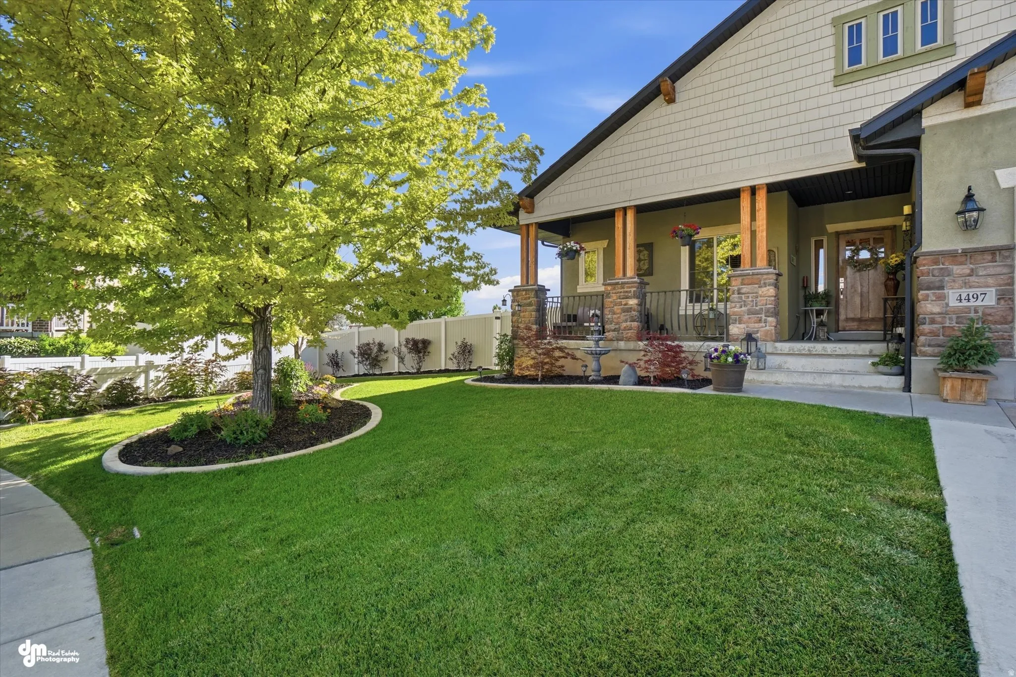 Craftsman-style home featuring a covered front porch with stone-clad columns and wood beam accents