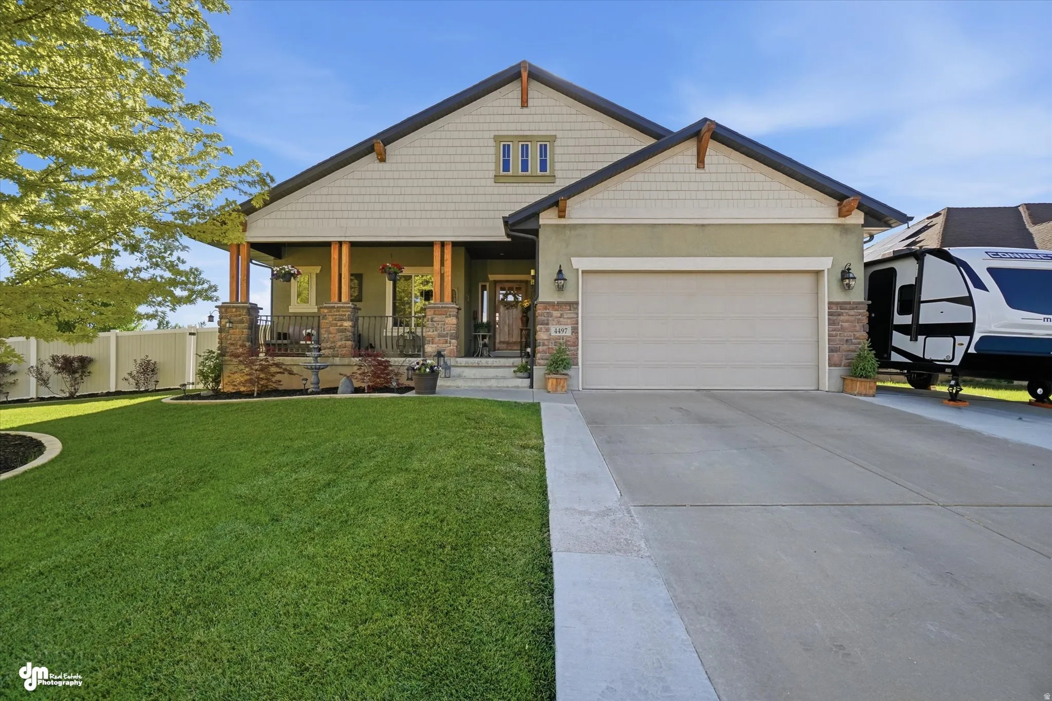 Craftsman-style exterior featuring a covered front porch with stone-clad columns and wood supports