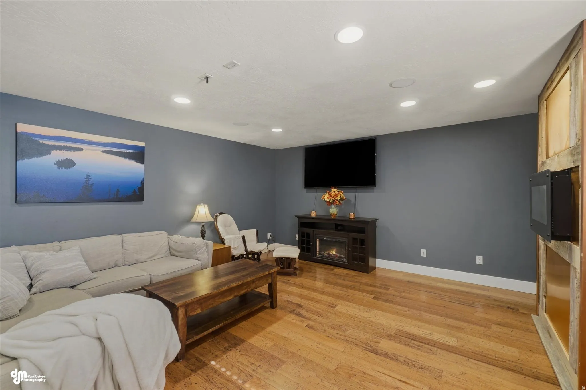 Hardwood-style flooring throughout this room, featuring recessed lighting and white baseboards