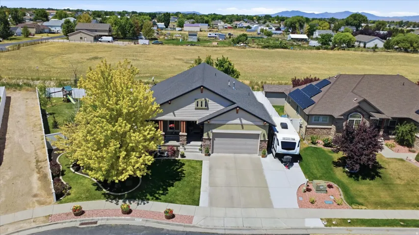 Front exterior with an attached garage, landscaped yard, and paved driveway