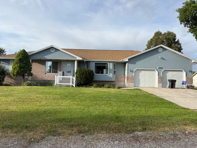 Ranch-style exterior featuring light blue siding with brick veneer accents and a brown shingle roof